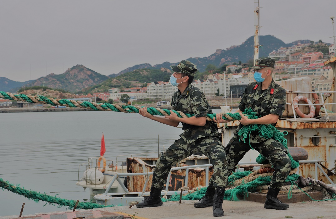 山东海警局执法员协助渔船民加固缆绳（2022年7月7日摄）。新华社发（董利虎 摄）.jpg