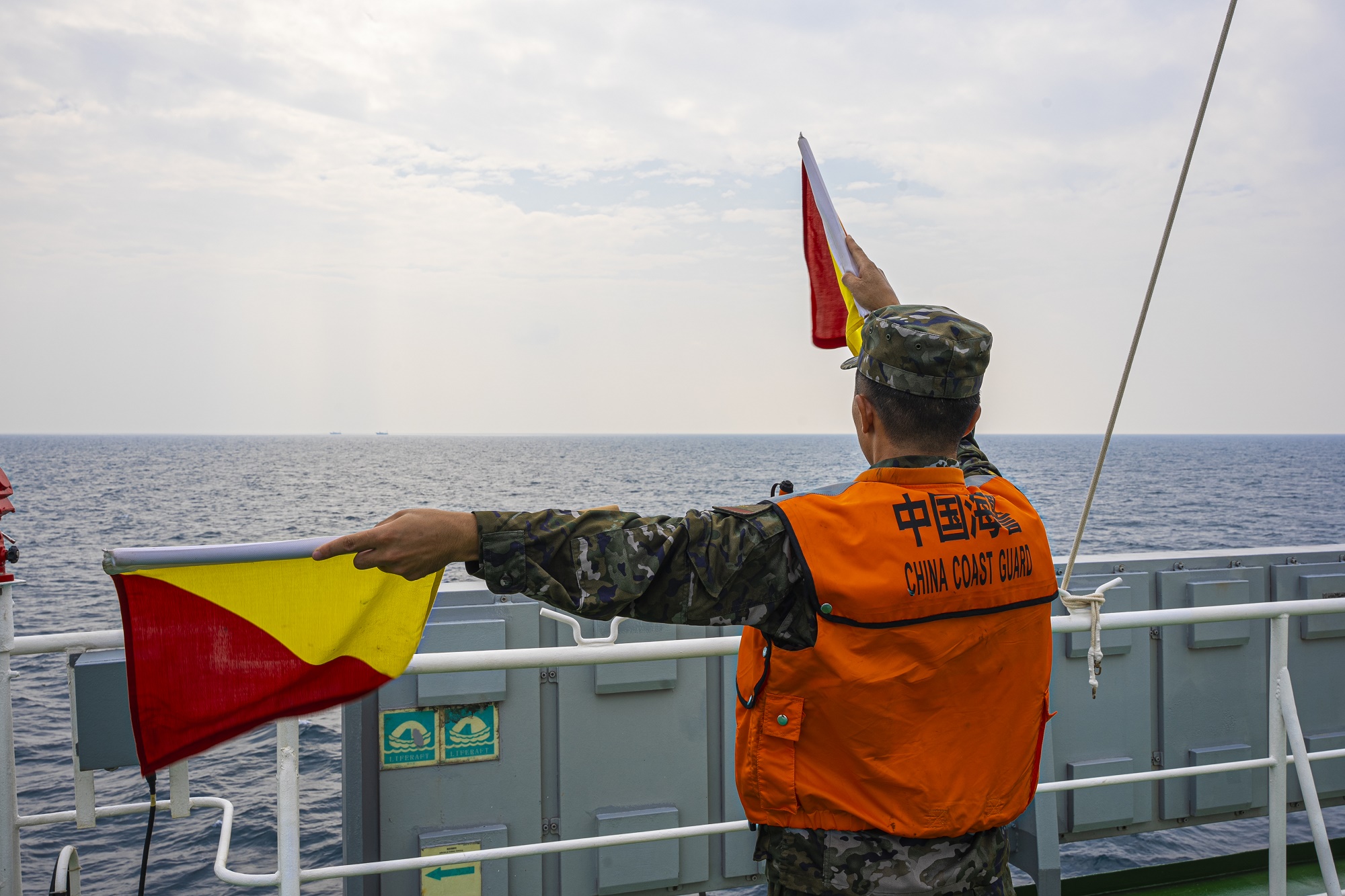 中国海警4304舰执法员在中越联合巡航期间使用信号旗对船只进行引导（2022年11月4日摄）。新华社发(骆天元 摄).jpg